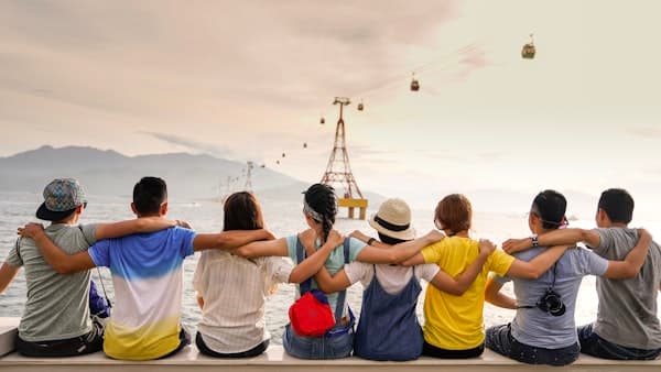 Group of friends with arms around each other looking at the horizon